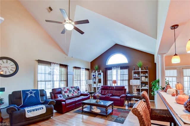 living room with decorative columns, high vaulted ceiling, ceiling fan, and plenty of natural light