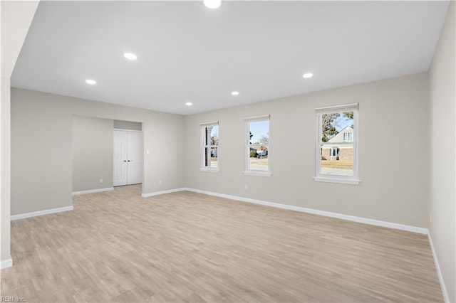 spare room featuring a wealth of natural light and light hardwood / wood-style flooring