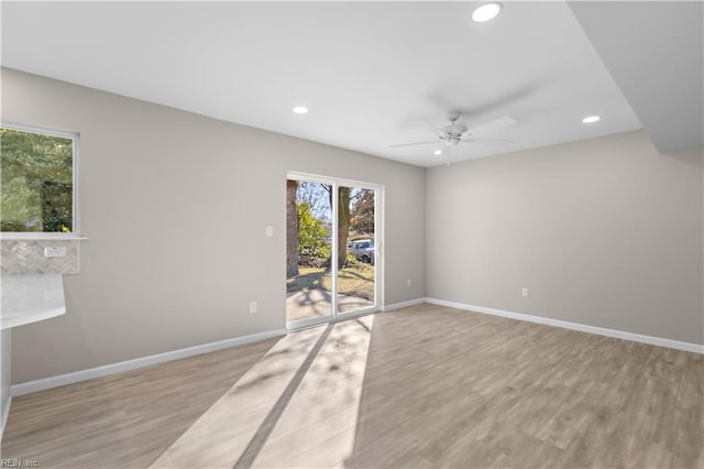 empty room with ceiling fan and light hardwood / wood-style flooring