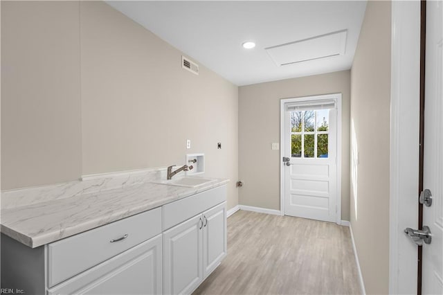 laundry room featuring sink, light hardwood / wood-style flooring, washer hookup, electric dryer hookup, and cabinets