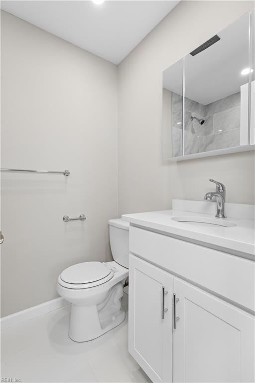 bathroom featuring toilet, tile patterned flooring, and vanity