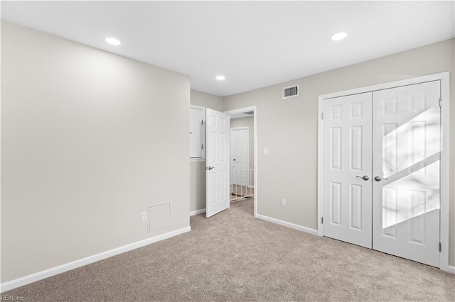 unfurnished bedroom with a closet and light carpet