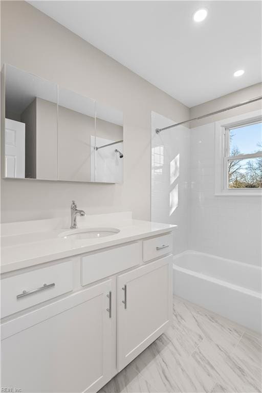 bathroom with tiled shower / bath and vanity