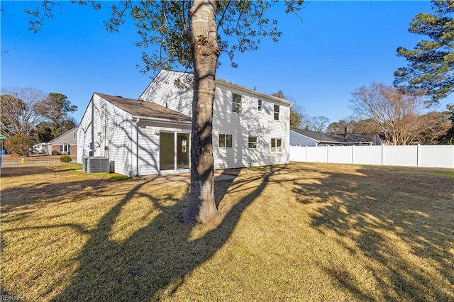 rear view of house with a lawn and central air condition unit