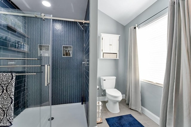 bathroom featuring toilet, vaulted ceiling, tile patterned floors, and a shower with shower door