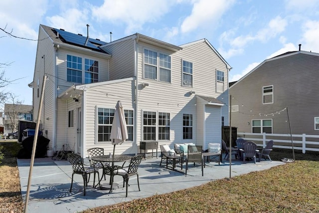 rear view of house with an outdoor hangout area, a patio area, a lawn, and solar panels