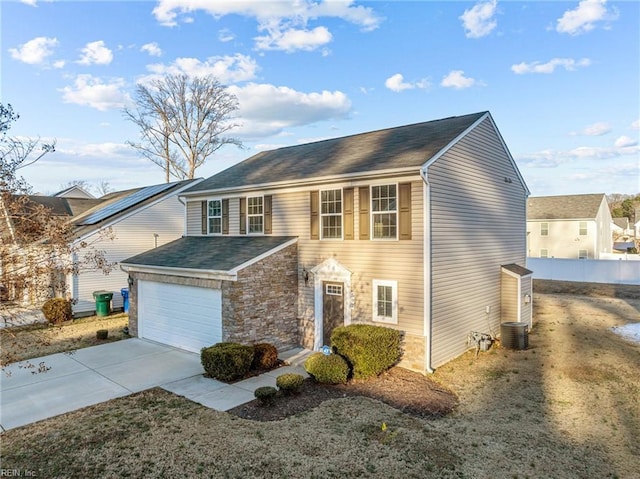 front of property featuring central AC unit and a garage