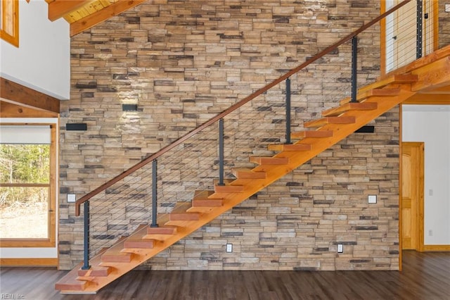 stairs with high vaulted ceiling, beam ceiling, wood-type flooring, and wood ceiling