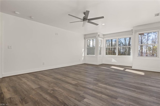 unfurnished room featuring ceiling fan, dark hardwood / wood-style flooring, and plenty of natural light