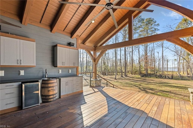 wooden deck with ceiling fan, a yard, and wine cooler