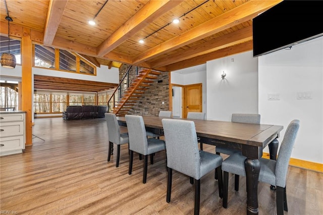 dining area featuring light hardwood / wood-style floors, wooden ceiling, beam ceiling, and rail lighting