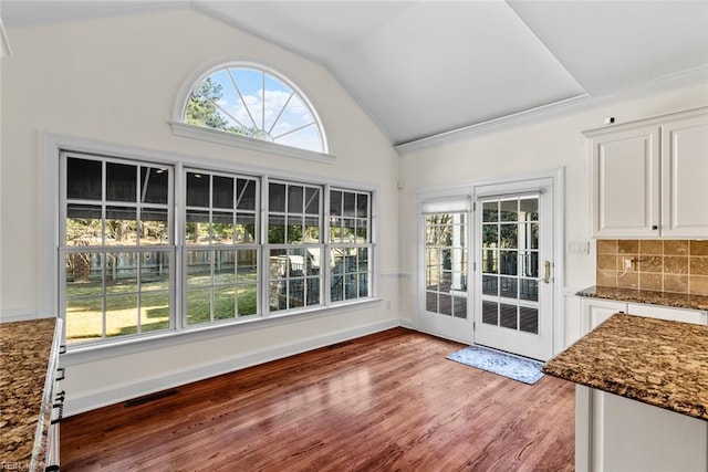 entryway with hardwood / wood-style floors and vaulted ceiling