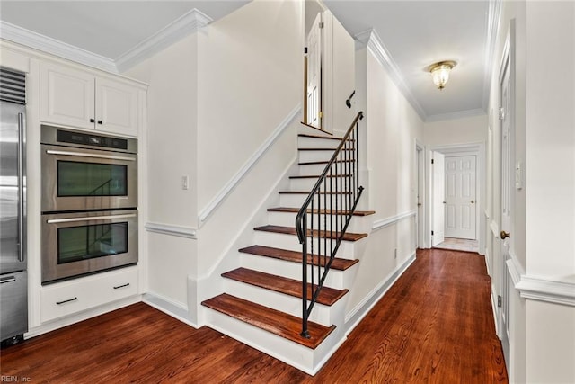 staircase with wood-type flooring and crown molding