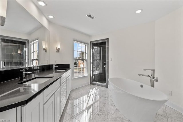 bathroom with vanity and shower with separate bathtub