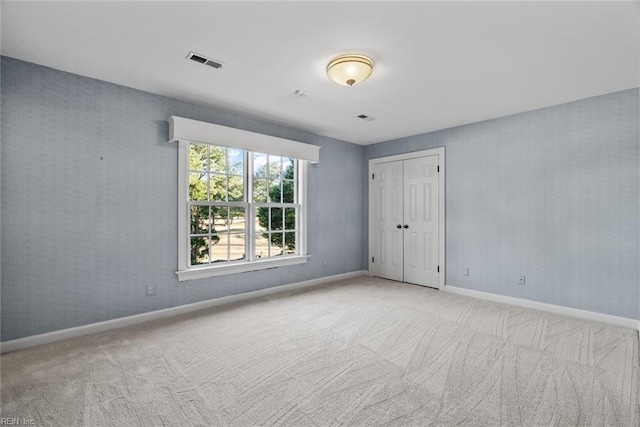 unfurnished room featuring light carpet