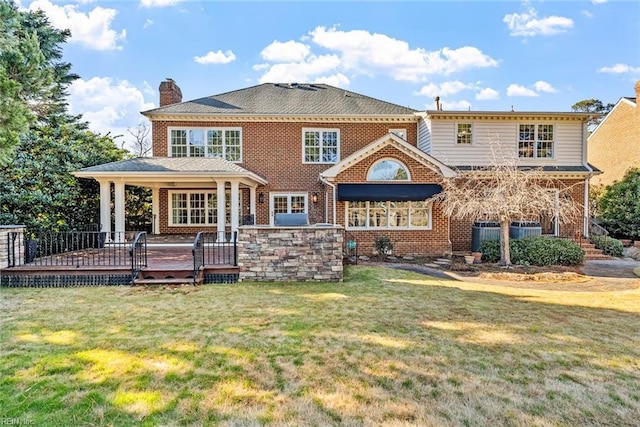 rear view of house featuring a yard and a wooden deck