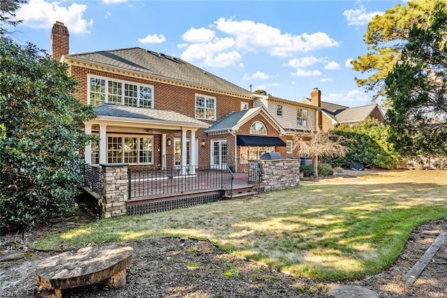 back of property featuring a lawn and a wooden deck