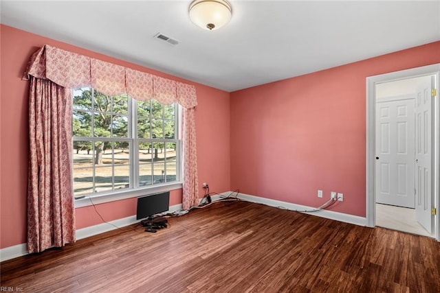 spare room with hardwood / wood-style flooring and plenty of natural light