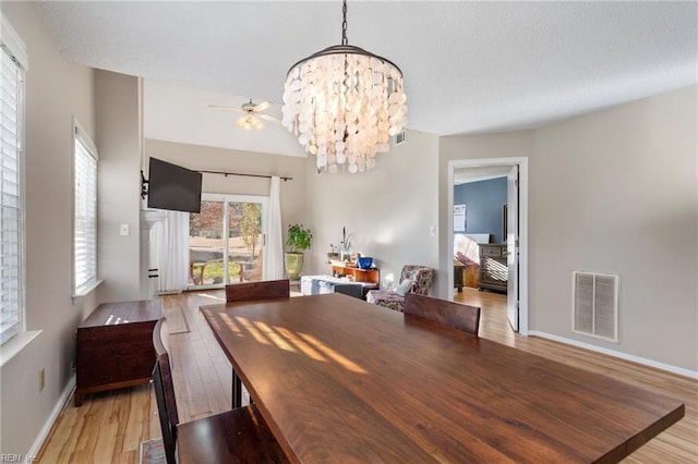 dining space featuring ceiling fan with notable chandelier, light hardwood / wood-style floors, and plenty of natural light