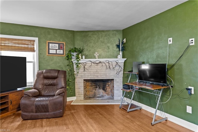 living room featuring a brick fireplace and hardwood / wood-style floors