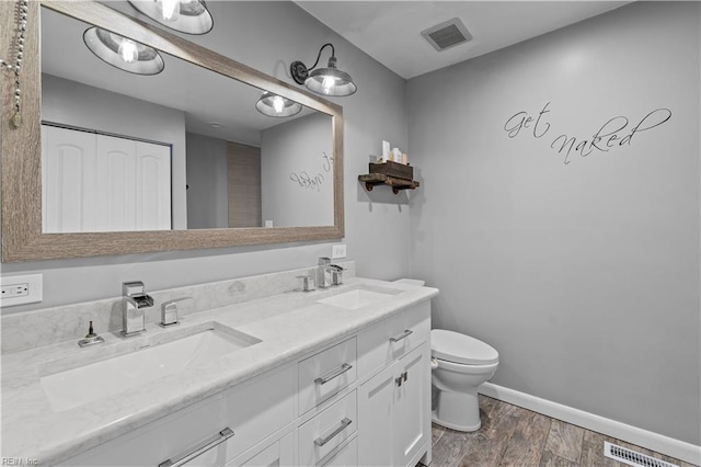 bathroom featuring toilet, wood-type flooring, and vanity