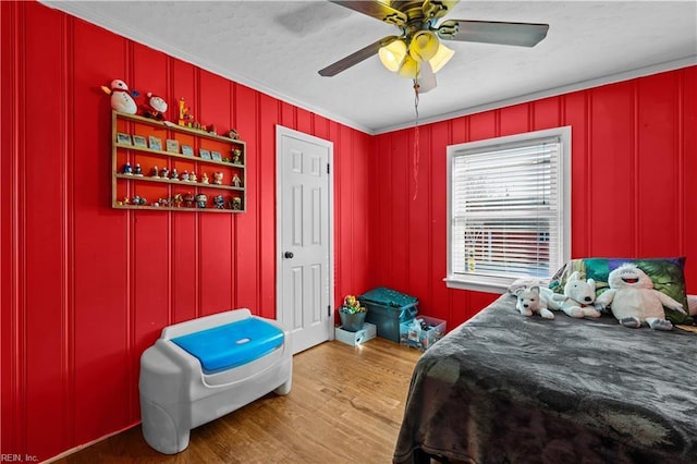 bedroom with hardwood / wood-style flooring, ceiling fan, and crown molding