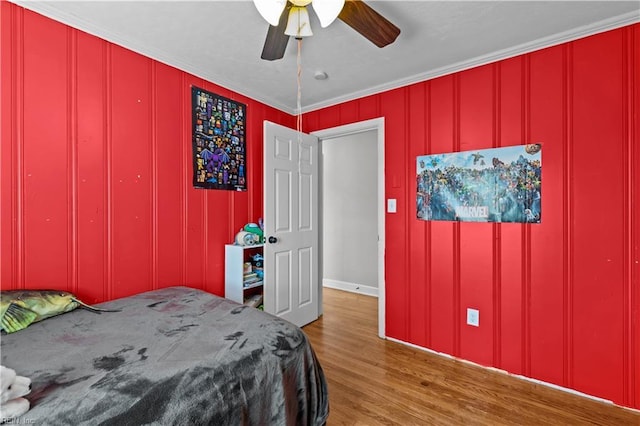 bedroom featuring ceiling fan, ornamental molding, and hardwood / wood-style floors