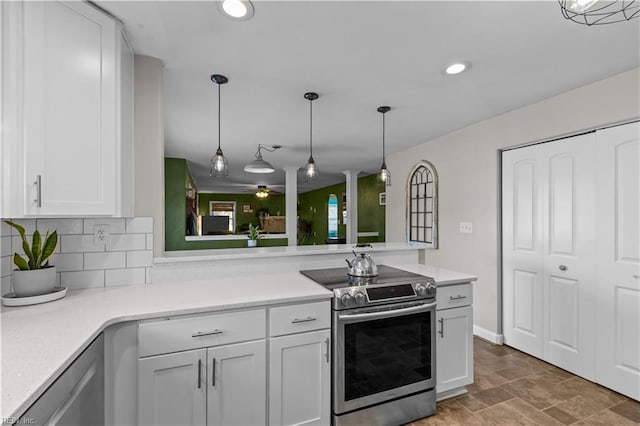 kitchen with appliances with stainless steel finishes, ceiling fan, decorative backsplash, white cabinetry, and decorative light fixtures