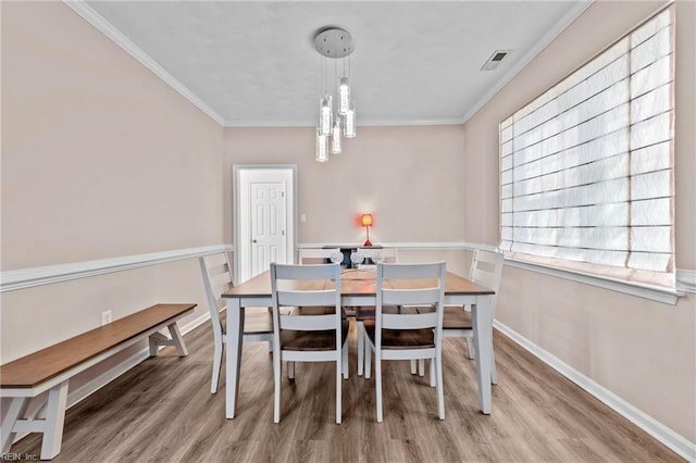 dining room featuring ornamental molding and hardwood / wood-style floors