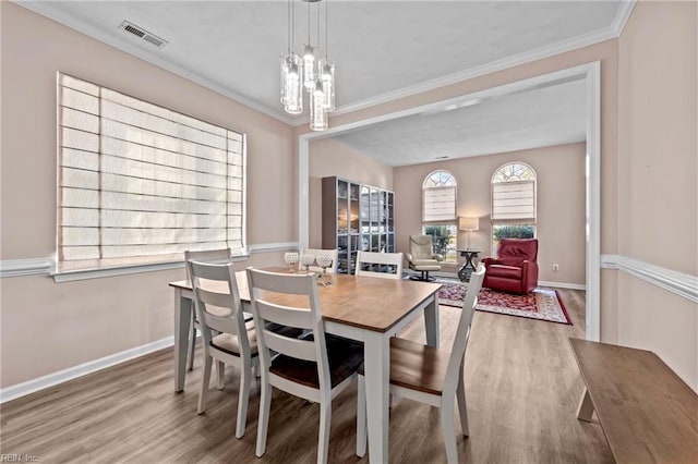 dining room featuring ornamental molding, a chandelier, and hardwood / wood-style floors