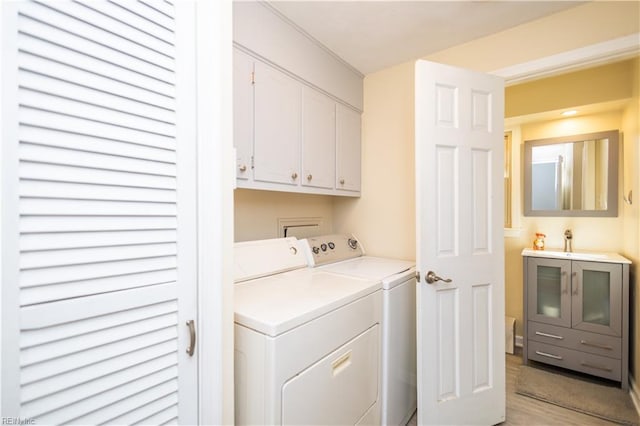 laundry area with sink, cabinets, and washer and clothes dryer