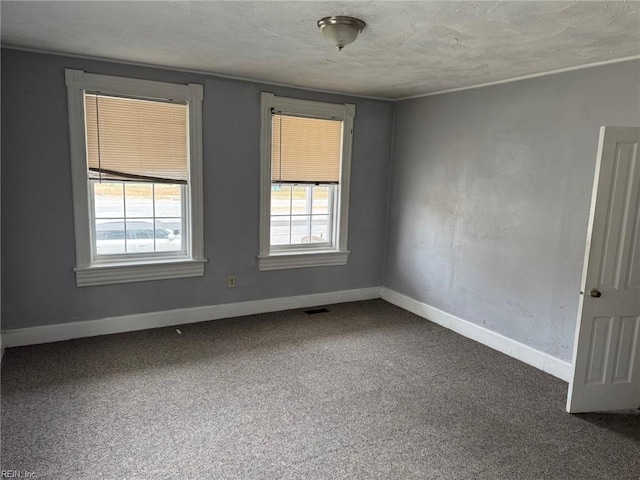 unfurnished room featuring a textured ceiling and carpet floors