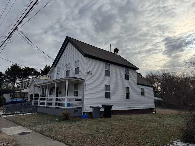 view of side of property featuring a yard and a porch