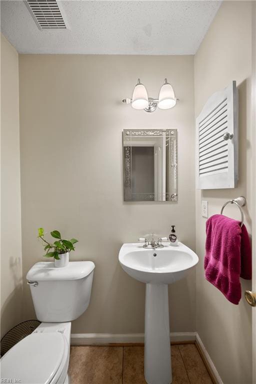 bathroom with toilet, a textured ceiling, tile patterned floors, and radiator heating unit