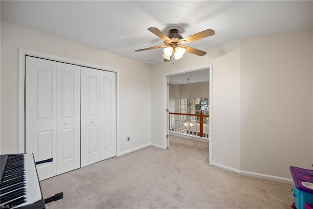 unfurnished bedroom with a closet, light colored carpet, and ceiling fan