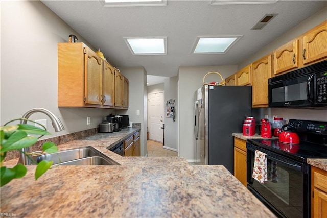 kitchen with sink, light tile patterned floors, and black appliances