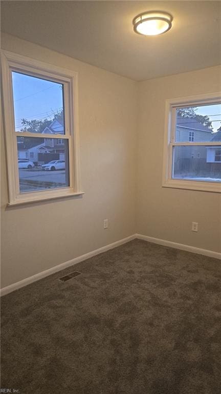 unfurnished room with dark carpet