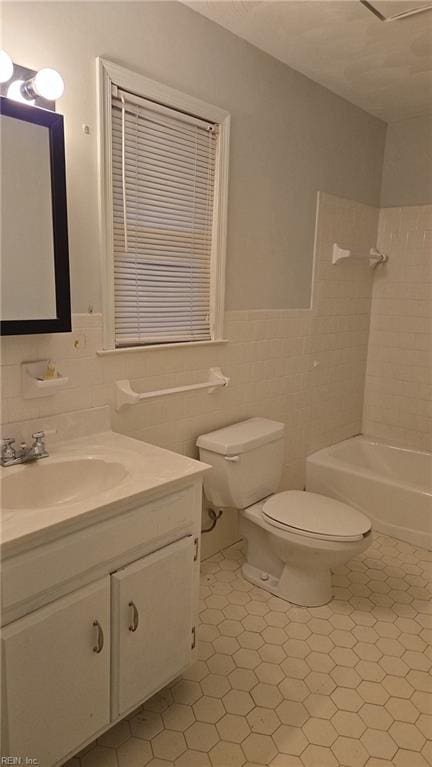 full bathroom with bathing tub / shower combination, tile patterned flooring, tile walls, toilet, and vanity