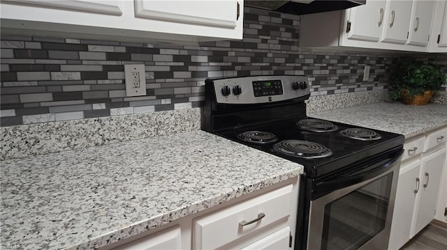 kitchen with white cabinetry, backsplash, light stone countertops, extractor fan, and electric range