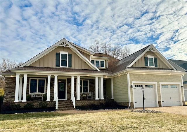 craftsman inspired home featuring covered porch, a front lawn, and a garage