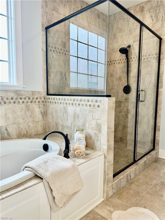 bathroom featuring shower with separate bathtub