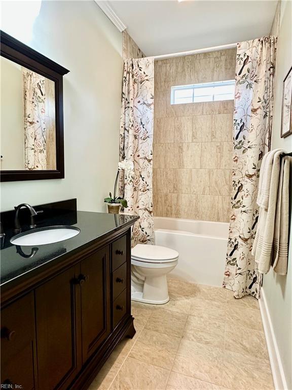 full bathroom with crown molding, shower / tub combo with curtain, vanity, and toilet