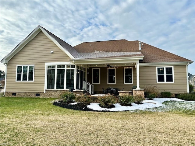 rear view of house featuring a patio, a yard, and a sunroom