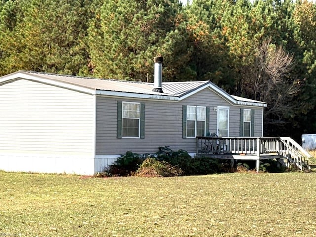 view of front of home with a wooden deck and a front lawn