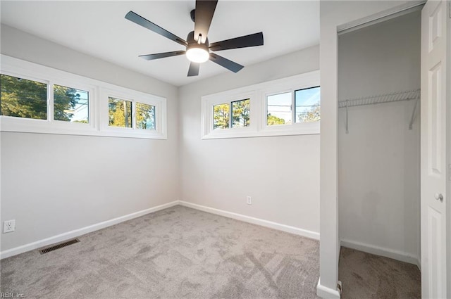 unfurnished bedroom featuring light colored carpet, ceiling fan, and a closet