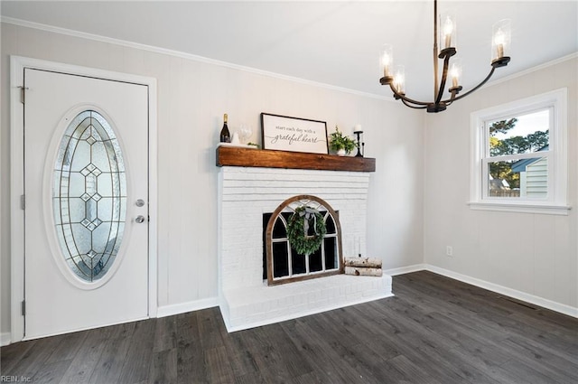 entrance foyer featuring a fireplace, an inviting chandelier, ornamental molding, and dark hardwood / wood-style floors