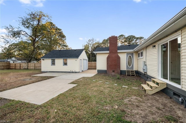 view of side of home with a lawn, a patio, and an outdoor structure