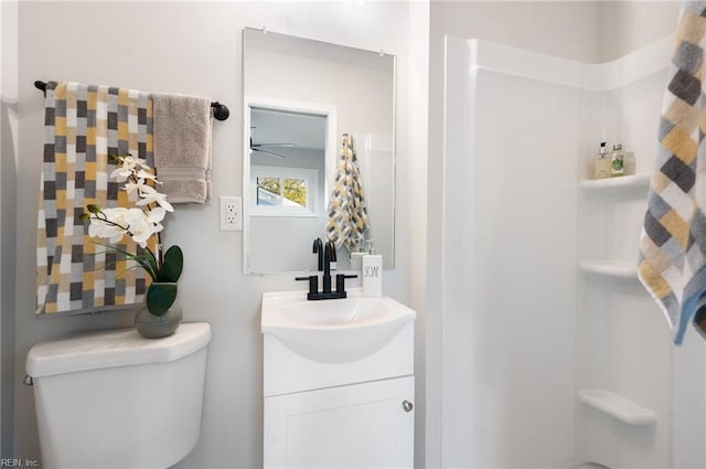 bathroom with a shower, vanity, and toilet