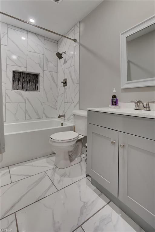 full bathroom featuring toilet, tiled shower / bath, and vanity