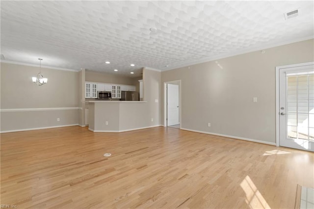 unfurnished living room featuring light wood-type flooring, ornamental molding, and an inviting chandelier